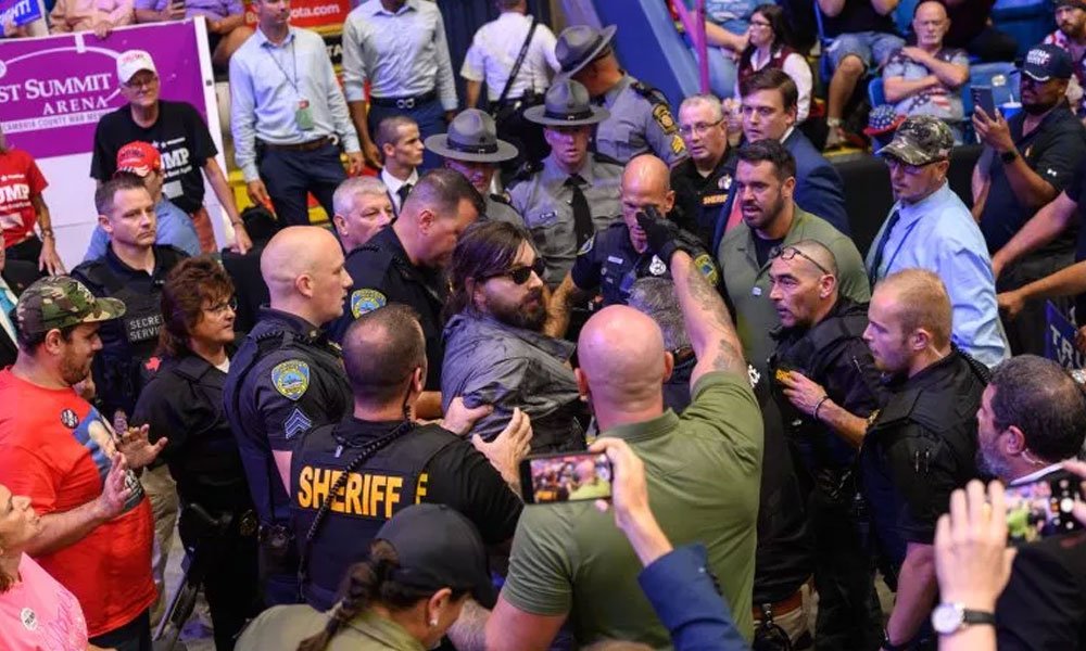 Security and law enforcement apprehend a Trump supporter at a campaign rally in Johnstown, Pennsylvania, on August 30, 2024. The man had jumped into a media area and climbed railings was Donald Trump attack the media as 'fake news.'