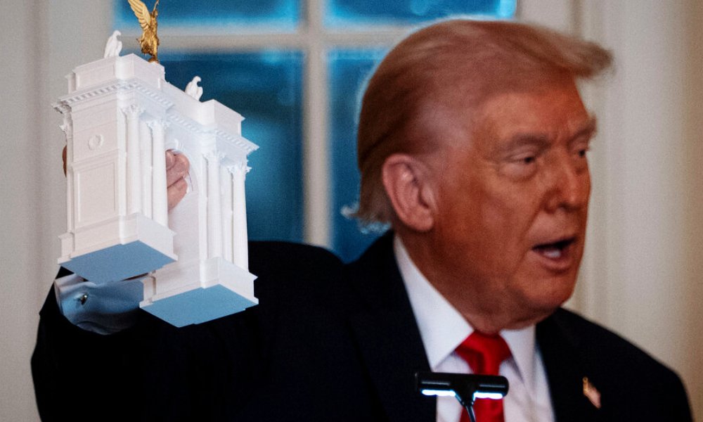 President Donald Trump holds a model of the proposed Triumphal Arch.